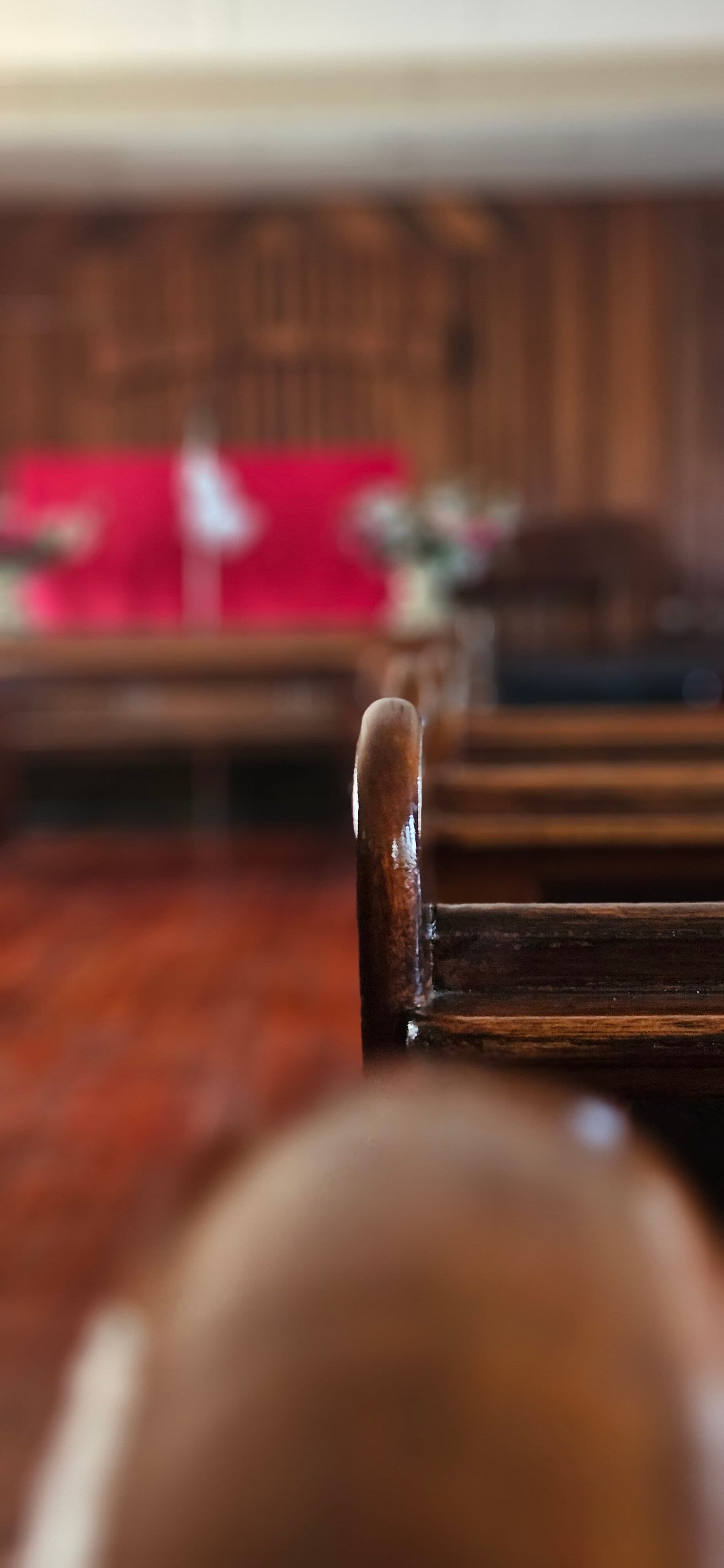 Empty wooden pews facing the pulpit inside The BRC sanctuary